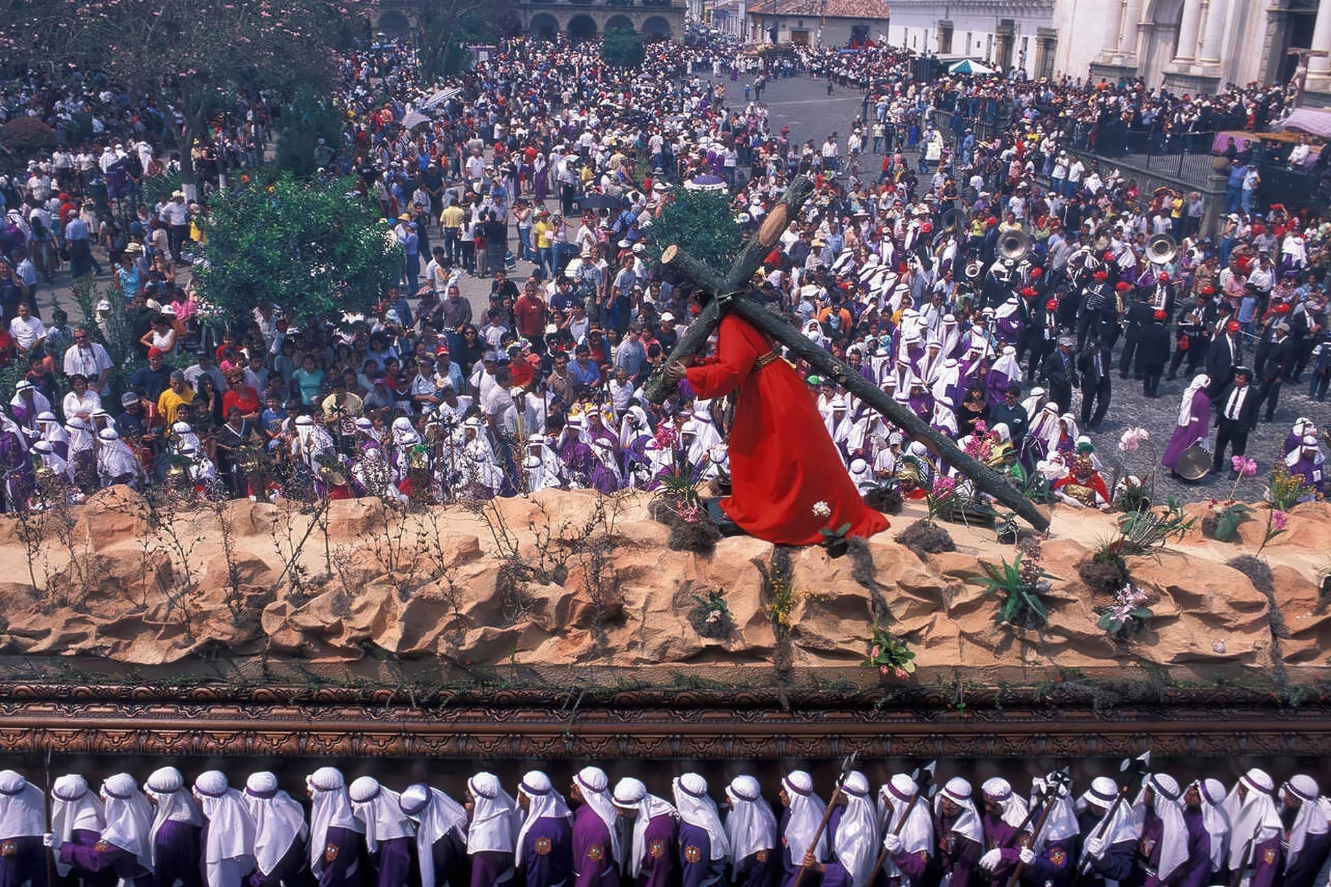 Close-up of costaleros raising a heavy paso, their feet barely visible beneath the velvet draping, sweat and commitment engraved on their cheeks.